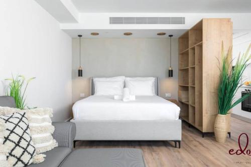 埃拉特דירה בסי סייד עם נוף מדהים לים - By Edom的卧室配有白色的床和沙发