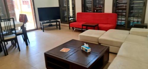 Al BurjFlat One Room Apartment Talabay Aqaba的带沙发和红色椅子的客厅
