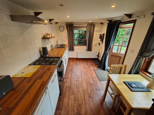 LlynclysThe Garden Lodge的铺有木地板,设有带炉灶的厨房。