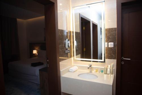 沙鲁拉فندق نوفا بارك的一间带水槽和镜子的浴室以及一张床