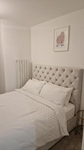 巴尔金Stylish Furnished Room In Barking Centre的一间卧室配有一张带白色床单的大床