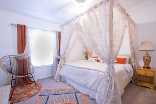 盖恩斯维尔Modern Boho Condo with a Royal Touch -KING BED的一间卧室设有天蓬床和窗户。