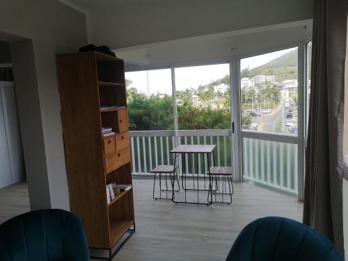 努美阿Moana Beach Apartment的客房设有带桌子和凳子的阳台。