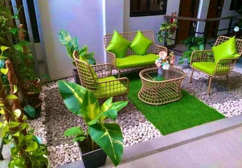 卡加盐德奥罗Dachannry's Place Hotel的庭院设有绿色椅子、植物和草地