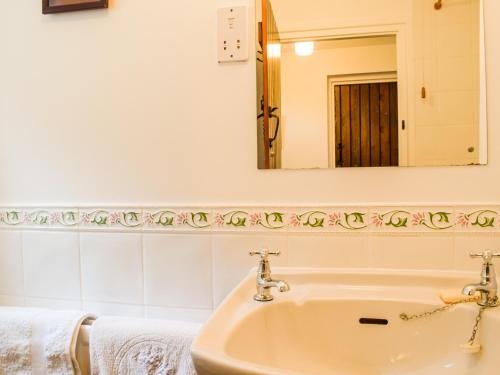 WollastonThe Hill Cottage Apartment的一间带水槽和镜子的浴室