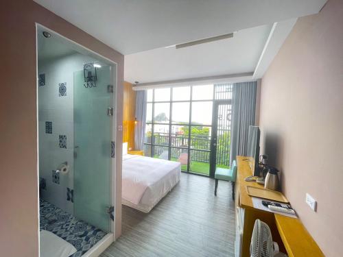 垦丁大街35点5旅店 的酒店客房带一张床和一个玻璃淋浴间