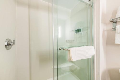 格林斯伯勒Fairfield by Marriott Inn & Suites Greensboro Coliseum Area的玻璃门淋浴和毛巾