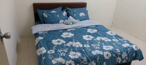 甘孟Bambob Homestay and Car Rental的一张带蓝色和白色棉被和枕头的床