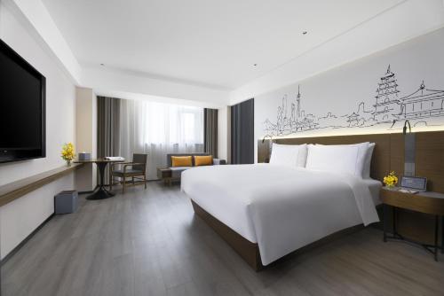 西安西安雁塔高新逸扉酒店的酒店客房设有一张大床和一台电视机。