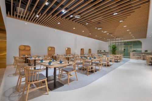 杭州杭州火车东站钱唐嘉客酒店的用餐室配有木桌和椅子
