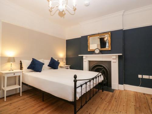 弗罗姆Vallis Oak Villa的一间卧室配有一张蓝色墙壁的床和壁炉