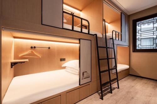 南京南京夜泊秦淮尊经书院酒店的一间位于小房子内的卧室,配有双层床