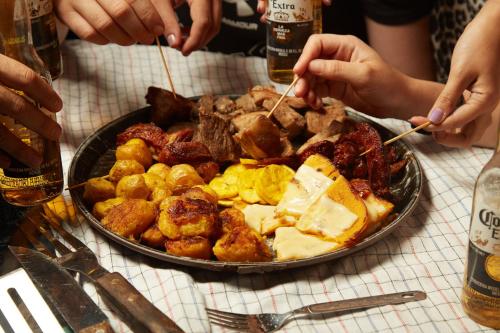 比亚维森西奥Glamping Itawa & Ecoparque turístico的桌上的一块食物,人们吃