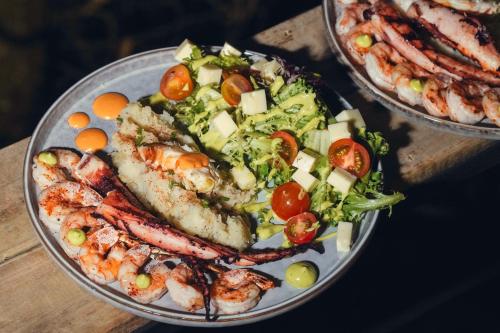 比亚维森西奥Itawa Luxury Glamping & Ecoparque turísticos的桌上一盘带虾和沙拉的食物