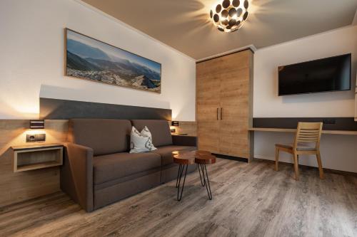 蒂罗尔-泽费尔德Das Aparthotel Olympia Tirol的客厅配有沙发和桌子