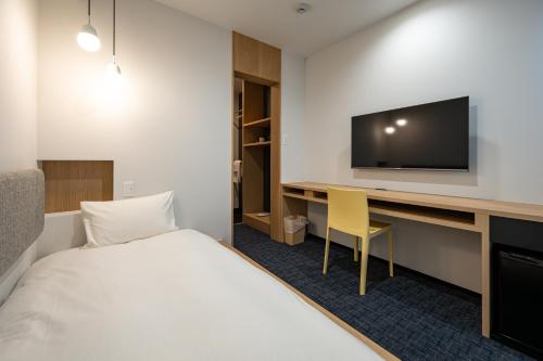 Bungotakadaplainn by negura的酒店客房设有一张床和一张带电视的书桌。