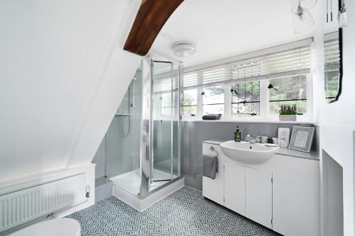 拉斯廷顿Walnut Tree House的带淋浴和盥洗盆的白色浴室