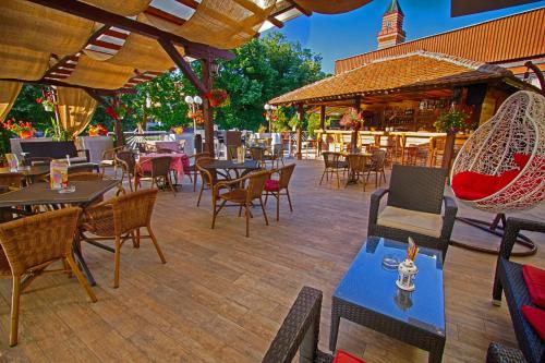 帕拉钦佩特鲁斯酒店的户外庭院配有桌椅和桌子。