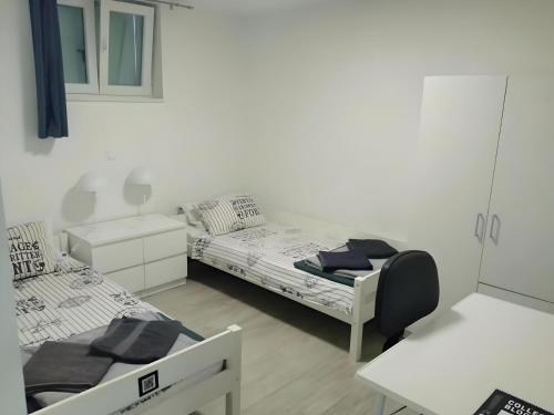 瓦布里加Apartment Patrik的白色的客房配有两张床和一张书桌