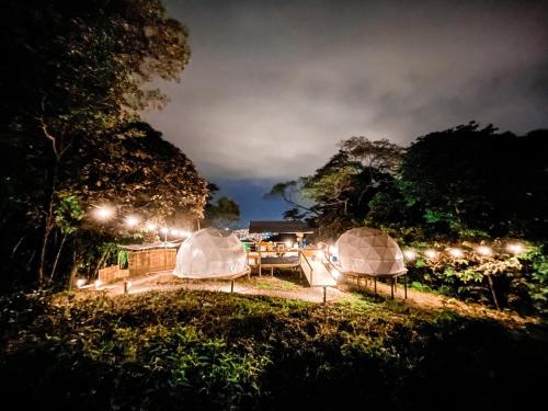 比亚维森西奥Itawa Family Glamping & Ecoparque turístico的一群帐篷在晚上在田野里