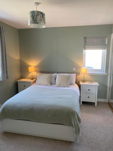 斯特罗姆内斯NEW pet friendly holiday home, sleeps 6, Stromness的一间卧室配有一张带2个床头柜和2盏灯的床。