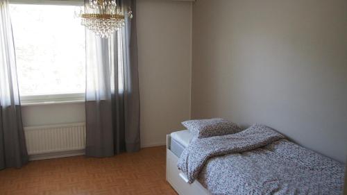 罗瓦涅米Lumi Room的一间卧室配有一张带吊灯和窗户的床。