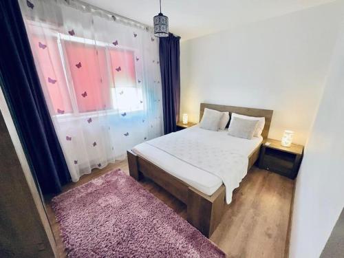 巴克乌Apartament in Regim Hotelier的卧室配有白色的床和粉红色地毯。