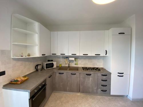 菲夏诺Casa Lia的厨房配有白色橱柜和水槽