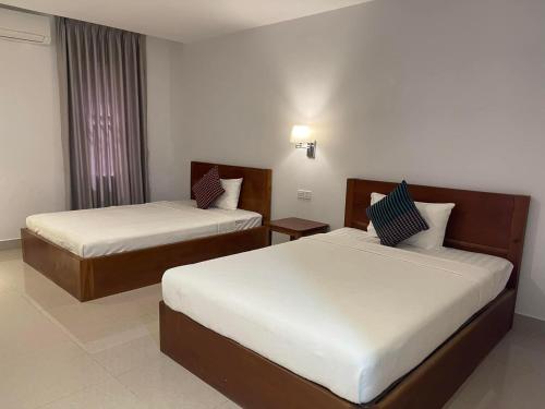 Chhay Ing Guesthouse的酒店客房设有两张床和窗户。
