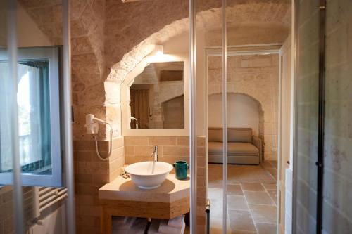 奥斯图尼Masseria Grieco的一间带水槽和玻璃淋浴的浴室