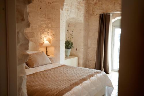 奥斯图尼Masseria Grieco的一间卧室配有一张石墙床