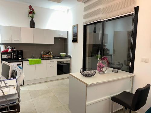 布拉柴维尔SYN - Corniche的厨房配有白色橱柜和台面