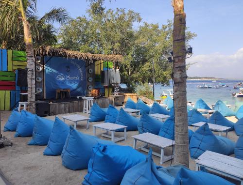 吉利特拉旺安Lisa Homestay的海滩上一组蓝色枕头和桌子