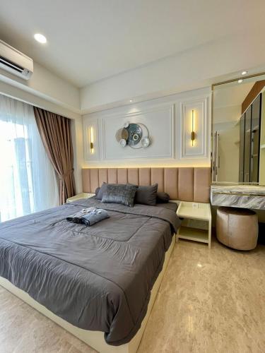 棉兰Insta-worthy staycation at 2BR luxury Apt - Podomoro Empire Tower的一间卧室设有一张大床和一个大镜子