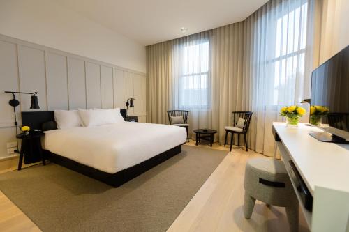 墨尔本考伯史密斯酒店的配有一张床和一张书桌的酒店客房