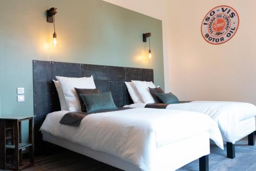 温格舍姆Domaine La Grange Ungersheim - Chambres d'Hôtes L'Inspiration的卧室配有两张床,墙上有标志