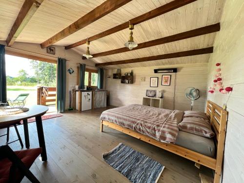 RimėnaiKaimukas - namelis prie ežero dviems的卧室配有一张床和一张桌子