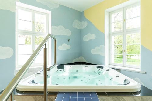 Mölln格罗斯赫勒旅馆的墙上涂有云彩的房间的浴缸