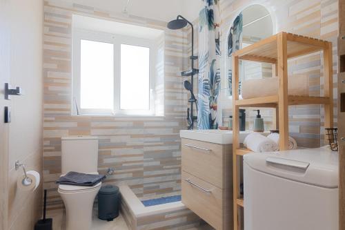 雅典Vivid Stays Petralona的一间带水槽和卫生间的浴室以及窗户。