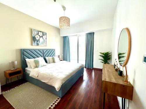 迪拜The Waves 241 Dubai Marina的一间卧室配有一张床、镜子和一张桌子