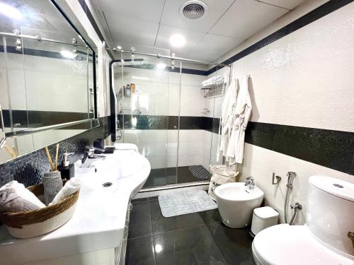 迪拜The Waves 241 Dubai Marina的黑白浴室设有两个盥洗盆和一个卫生间