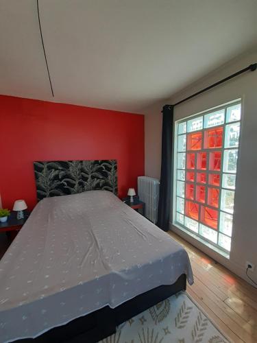 塞纳河畔埃皮奈Chambre d'hôte près de Paris的一间卧室设有一张床和一个大窗户