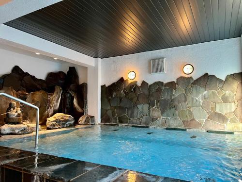 伊豆五叶馆的一个带岩石墙的房间的热水浴缸