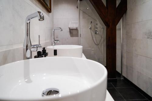 沃尔堡Central Park Voorburg - Relais & Chateaux的浴室配有白色水槽和淋浴。