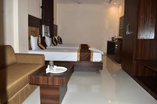 加雅Hotel Kusum Palace的酒店客房,配有床和沙发