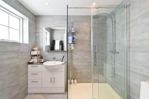 伦敦Large 3 Bedroom Covent Garden Apartment的一间带玻璃淋浴和水槽的浴室