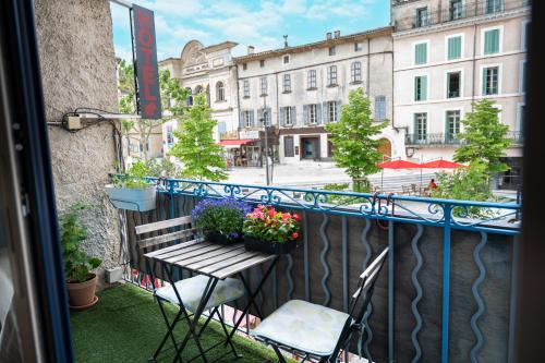 阿普特Hôtel-restaurant le Palais的阳台配有长凳和花盆