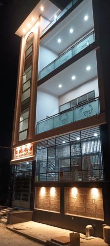 马图拉Shree shyam kunj Home stay的一座高大的建筑,旁边灯火通明