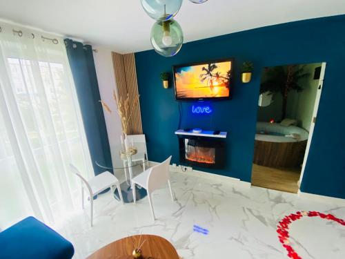 普瓦西Exotic spa的一间客厅,客厅的蓝色墙壁上配有电视