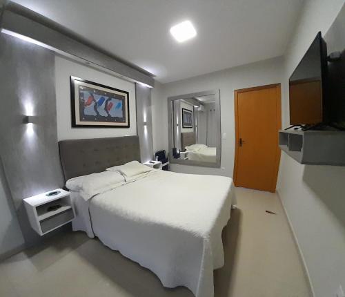 南圣克鲁斯Santa House no Centro的卧室配有白色的床和镜子